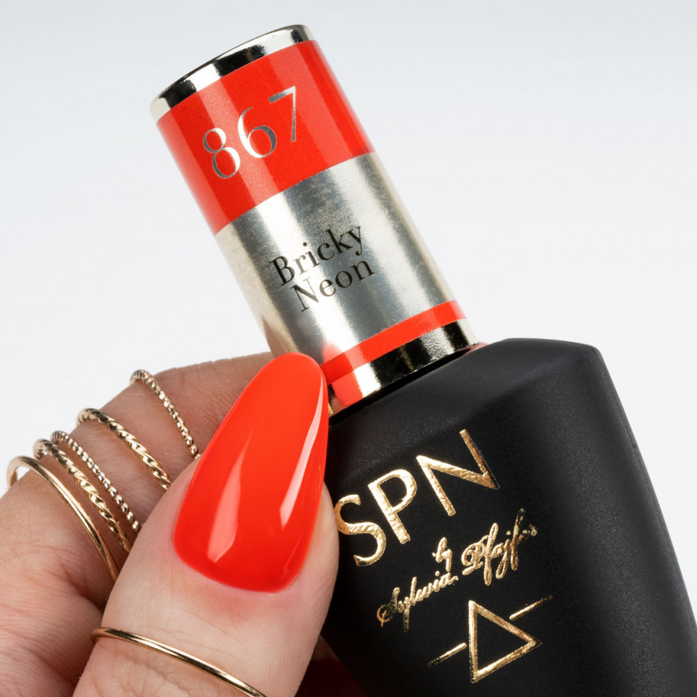 Butelka z lakierem hybrydowym i kciuk pomalowany neonowym czerwonym kolorem Butelka z lakierem hybrydowym i kciuk pomalowany neonowym czerwonym kolorem