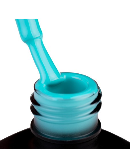 Szyjka butelki i oparty o nią pędzelek zanurzony w lakierze hybrydowym 964 Caribbean Sea w kolorze turkusowym