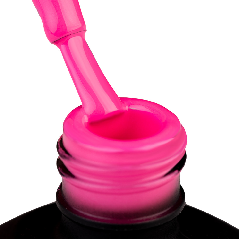 Szyjka butelki i oparty o nią pędzelek zanurzonyw cukierkowo różowym lakierze hybrydowym