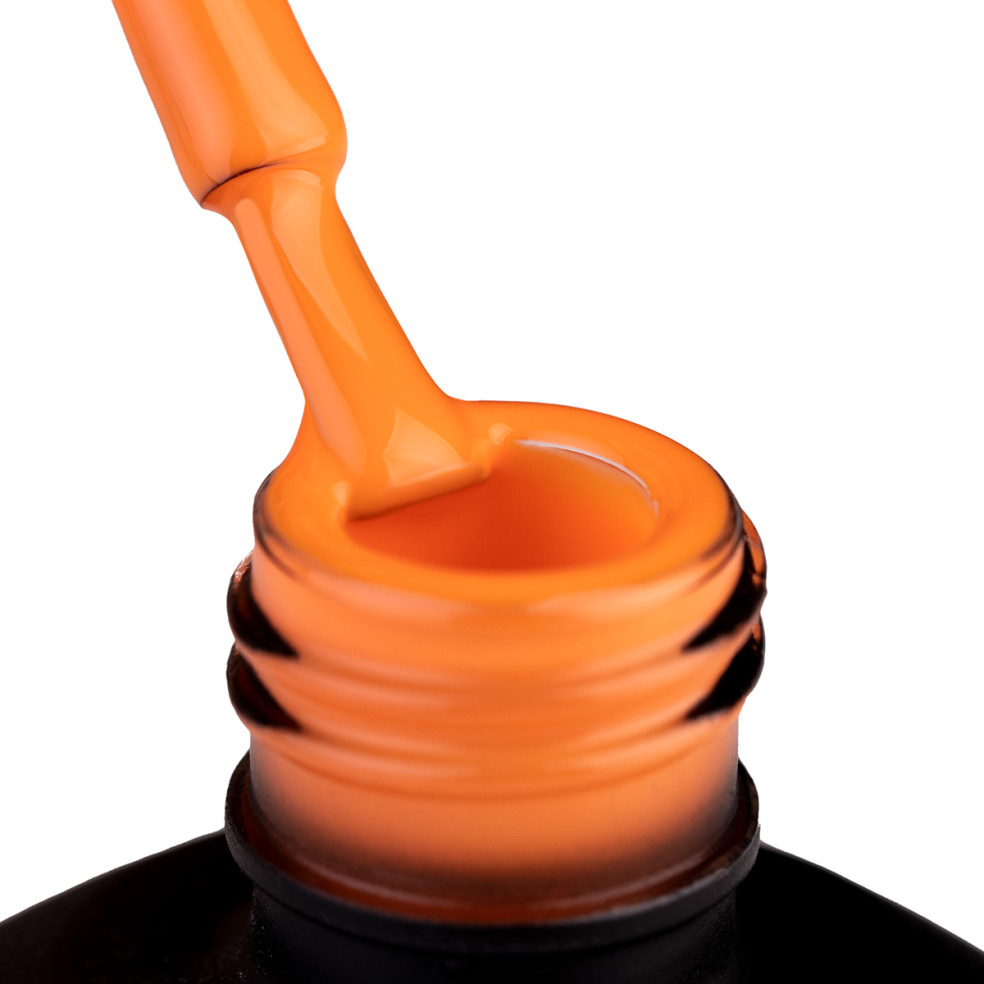 Szyjka butelki i oparty o nią pędzelek zanurzony w pomarańczowym lakierze hybrydowym 968 Spritz Baby!