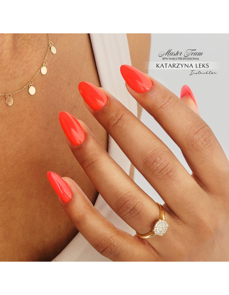 Paznokcie pomalowane nonowym pomarańczowym lakierem.