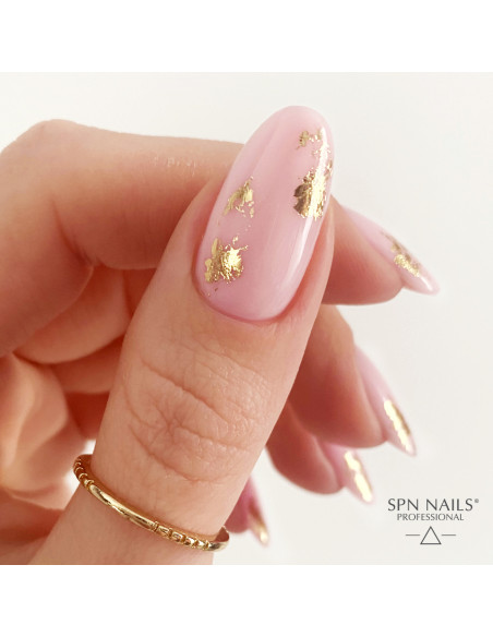 Zbliżenie na kciuk. Paznokcieć pokryty bazą kauczukową w kolorze pudrowego różu Candy Girl Zbliżenie na kciuk. Paznokcieć pokryty bazą kauczukową w kolorze pudrowego różu Candy Girl