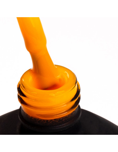 Pędzelek zanurzony w neonowym pomarańczowym lakierze hybrydowym Pędzelek zanurzony w neonowym pomarańczowym lakierze hybrydowym