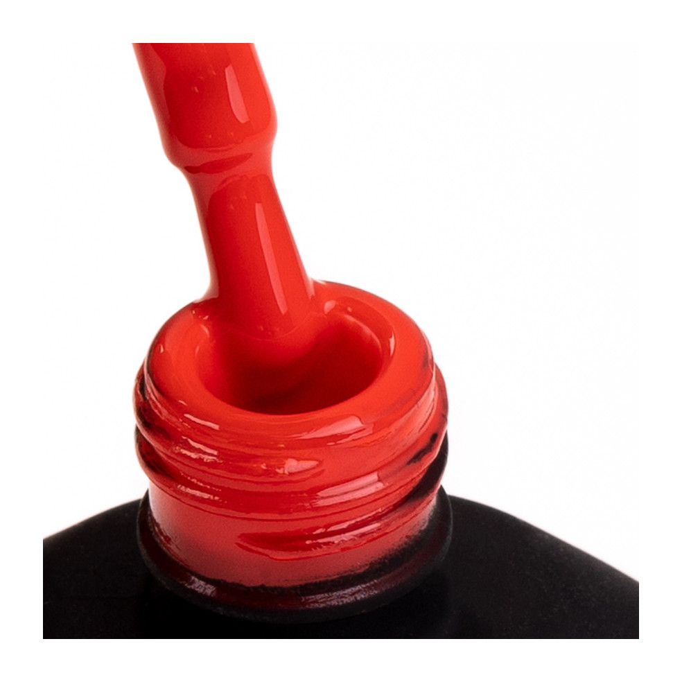 Pędzelek zanurzony w czerwonym lakierze hybrydowym