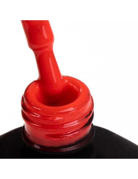 Pędzelek zanurzony w czerwonym lakierze hybrydowym