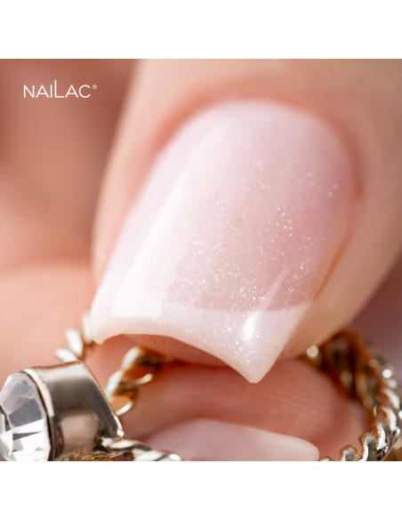 French manicure. Zbliżenie na kciuk pokryty bazą hybrydową VitaMilk w mleczym odcieniu z drobinkami. French manicure. Zbliżenie na kciuk pokryty bazą hybrydową VitaMilk w mleczym odcieniu z drobinkami.