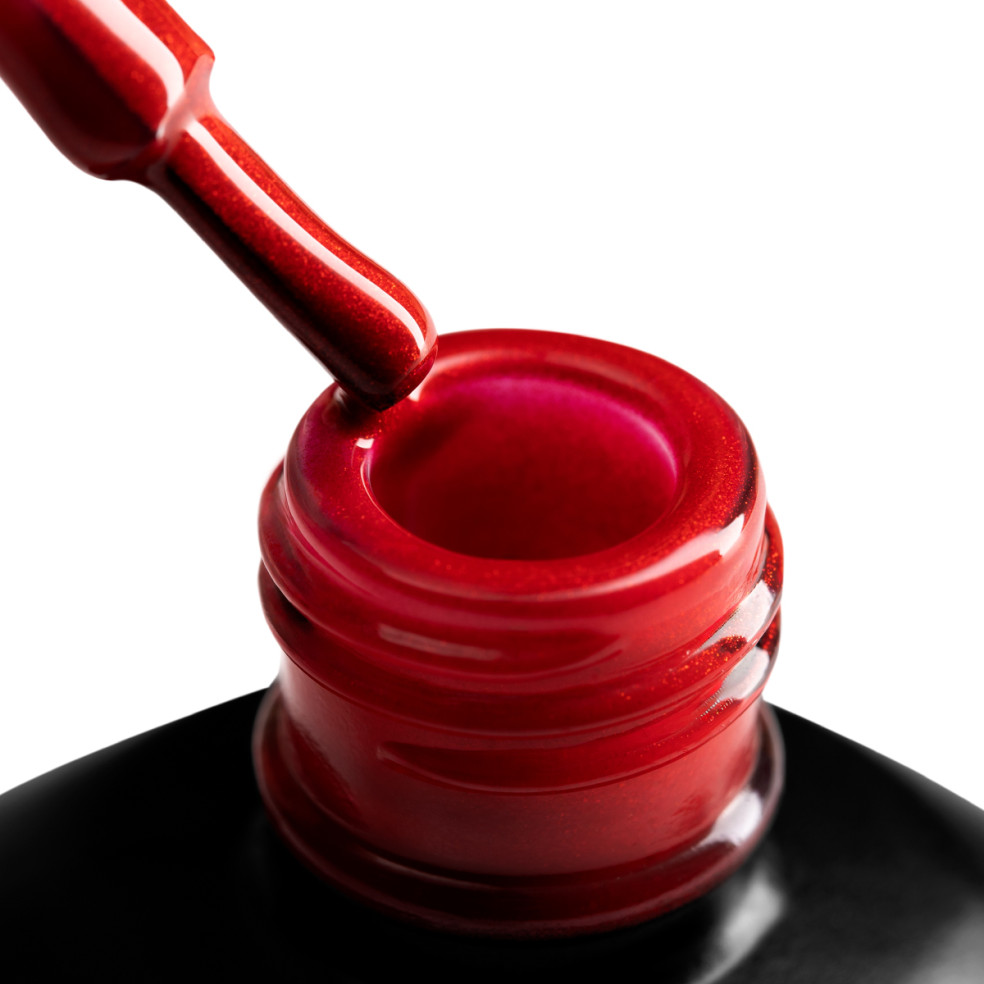 Szyjka butelki i oparty o nią pędzelek zanurzony w czerwonym brokatowym lakierze hybrydowym 1022 Make a Wish