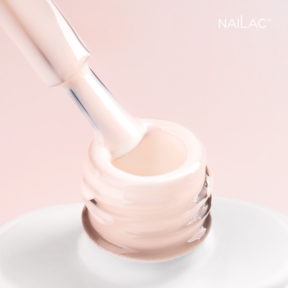 Szyjka butelki z pędzelkiem zanurzonym w lakierze hybrydowym pastelowym brzoskwiniowym