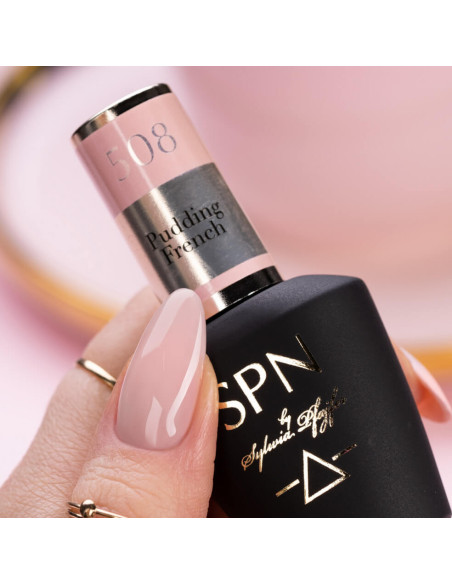 Butelka z lakierem hybrydowym i kciukiem pomalowanym lakierem w kolorze pudrowego różu Butelka z lakierem hybrydowym i kciukiem pomalowanym lakierem w kolorze pudrowego różu