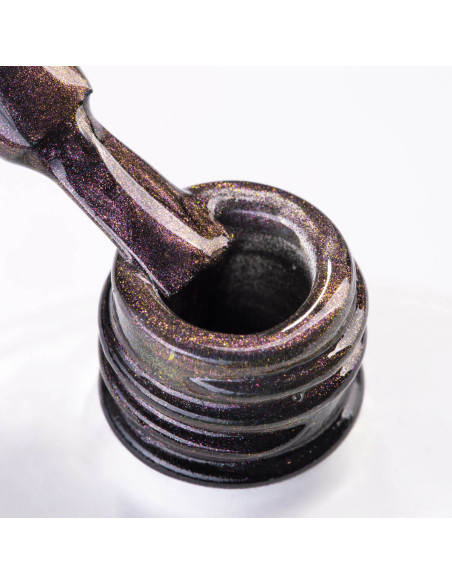 Szyjka butelki i pędzelek zanurzony w fioletowym lakierze hybrydowym z efektem cat eye Szyjka butelki i pędzelek zanurzony w fioletowym lakierze hybrydowym z efektem cat eye