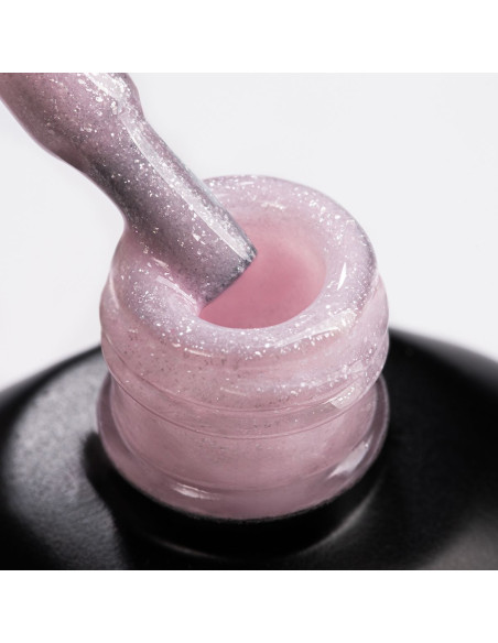 Pędzelek zanurzony w żelu do przedłużania paznokci w kolorze delikatnego różu
