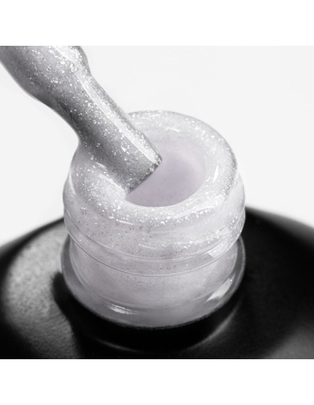 Pędzelek zanurzony w żelu do przedłużania w kolorze mlecznym z drobinkami