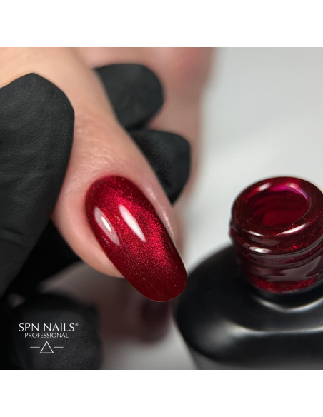 Paznokieć pomalowany czerwonym lakierem hybrdowym Cat Eye z efektem flash