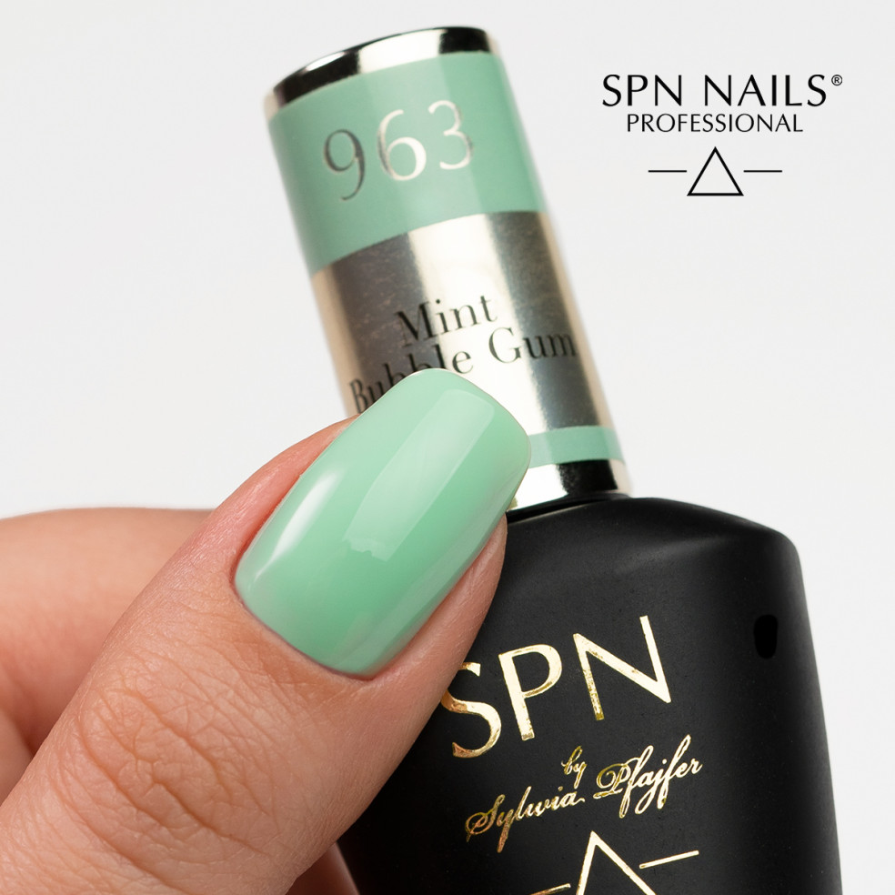 Butelka z lakierem i kciuk pomalowany kolorem szałwiowym 963 Mint Bubble Gum UV LaQ 8ml