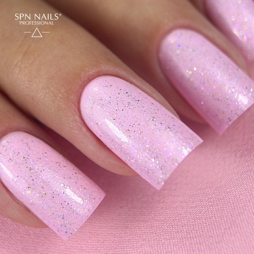Różowy manicure hybrydowy wykończony topem hybrydowym Glow Top Gloss Boss 10 ml z opalizującymi drobinkami