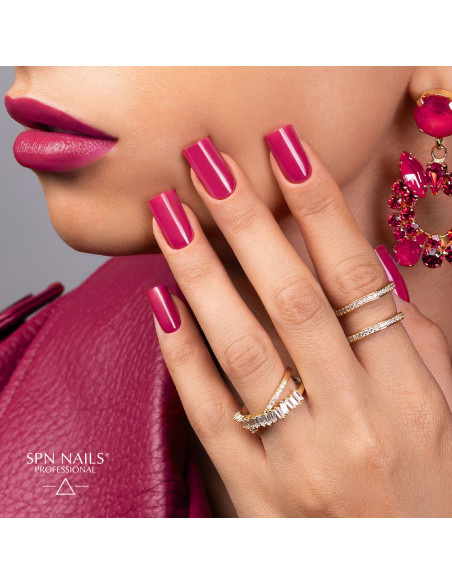 Manicure hybrydowy w kolorze fuksji wykonany lakierem 1043 Bad Intentions UV LaQ SPN Nails na dłoni modelki