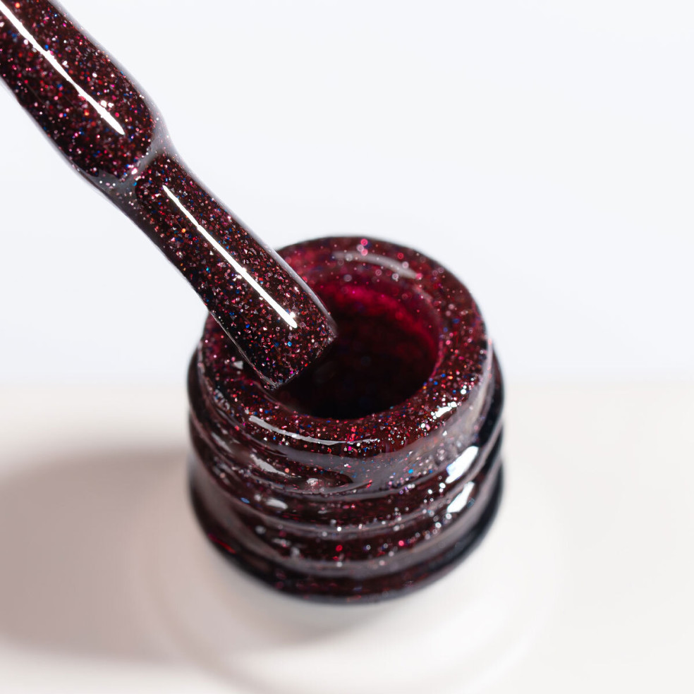 Zbliżenie na pędzelek lakieru hybrydowego NaiLac Sparkleholic ukazujące malinowy róż z brokatem i efektem flash